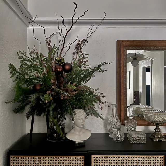 Depuis quelques années, je remplace le sapin par un grand bouquet de Noël.
Mon espace est petit et je préfère laisser la pièce respirer, tout en ajoutant une touche festive et naturelle qui s’intègre harmonieusement à mon décor.J’ai travaillé le sapinage comme une composition florale : des textures, des branches souples, quelques boules aux reflets bordeaux, des minis boules vertes, des rubans noirs et des éléments séchés pour une ambiance hivernale sobre et élégante.
Ce type d’installation prend moins de place et crée un point focal chaleureux sans alourdir l’espace.C’est exactement ce que j’aime dans la décoration : trouver des solutions qui respectent l’énergie des lieux et les transforment juste assez pour faire du bien. 💫Et vous, comment apportez-vous la magie de Noël dans votre espace ?PS: Vous pouvez voir toutes les photos dans mon article "Décorer un petit appartement pour Noël avec style" en lien dans le premier commentaire.#scèneintérieure #êtrebienchezsoi #chezmoi